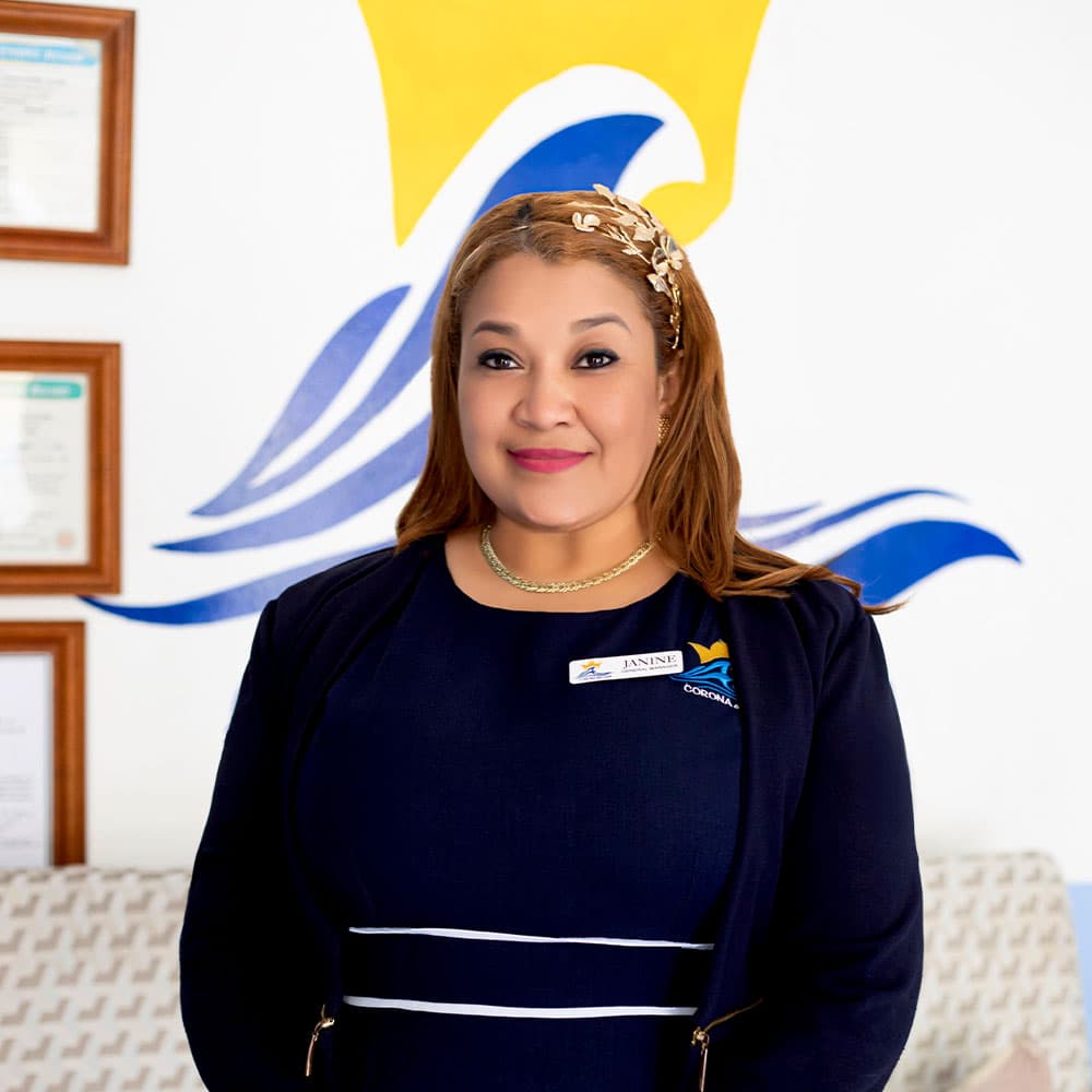 A woman with long brown hair and a headband poses in front of a colorful wave mural.
